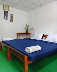 a large bed with blue sheets and white pillows at Wave Hunters Arugam Bay in Arugam Bay