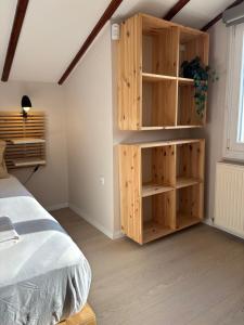 a bedroom with a wooden book shelf next to a bed at Centraal Blue in Iraklitsa