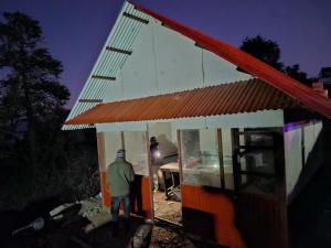 a man standing outside of a small building at Sunya Homestay in Kirāntīchhāp