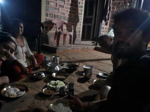 a group of people sitting around a table with bowls of food at Sunya Homestay in Kirāntīchhāp