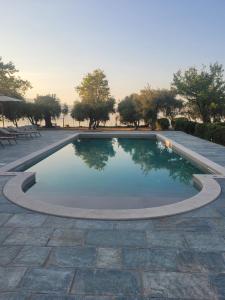 a swimming pool in a patio with trees in the background at Beachfront cottage house in olive grove in Arkitsa