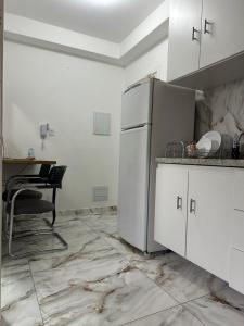 a kitchen with a refrigerator and a table in it at Apartamento 1 dorm,com ar,frente faculdade in São Paulo