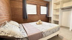 a bedroom with a bed and a brick wall at Rio - Destination Guyane in Macouria