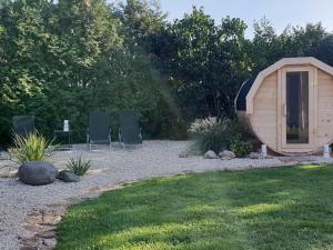a garden with a wooden shed and chairs at Schäferwagen Gartenblick Nr 4 in Radebeul