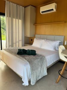 a bedroom with a white bed with a green bag on it at Villa D Castro in Gonçalves