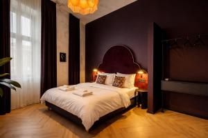 a bedroom with a large bed with a large headboard at Maroon & Moss Residence in Budapest