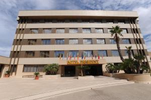 a building with a palm tree in front of it at Hotel President in Marsala