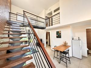 a staircase in a house with a kitchen and a table at Rio - Destination Guyane in Macouria