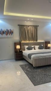 a large bedroom with a large bed and two lamps at شقق ثمانين بارك1 in Khamis Mushayt