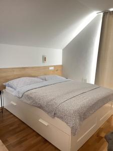 a white bed in a bedroom with a white wall at Apartmán pri Dierach in Terchová