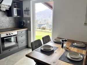 a kitchen with a wooden table with chairs and a dining room at Apple & Pear in Ročinj
