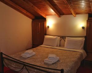 a bedroom with a bed with two towels on it at Driades in Kalavrita +10 photos