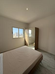 a white bedroom with a large bed and a window at AQUÁRIO Apart Hotel in Sal Rei