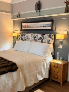 a bedroom with a bed and a nightstand with two lamps at Bryn Goleu Bed & Breakfast in Llandudno