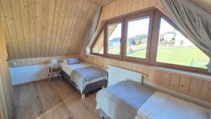 a small room with two beds and a window at Domki na Wymyślu in Grywałd