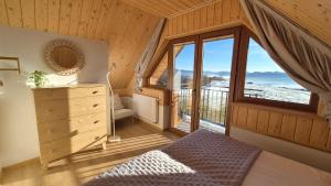 a bedroom with a bed and a large window at Domki na Wymyślu in Grywałd