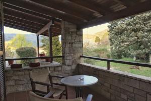 a patio with a table and chairs and a window at Driades in Kalavrita