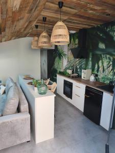 a kitchen with a couch and a table in a room at Escale à Clisson - Les jardins de Bali in Clisson