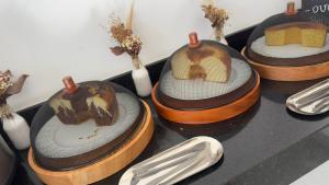a group of four cakes in wooden containers on a table at Pousada Na Serra in Ubajara