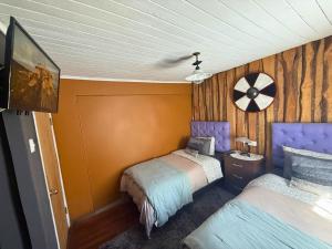 a bedroom with two beds and a tv in it at Hostal Suomi in Los Ángeles
