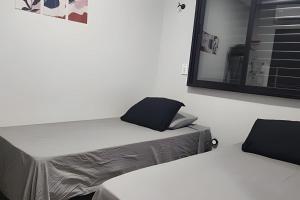 a white room with a bed and a mirror at Studio V - Com Ar Condicionado in Jundiaí