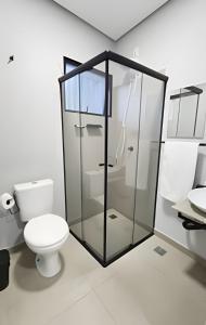 a bathroom with a toilet and a glass shower at Studio V - Com Ar Condicionado in Jundiaí +7 photos