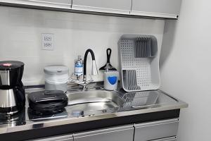 a kitchen counter with a sink and a microwave at Studio V - Com Ar Condicionado in Jundiaí
