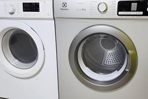 a white washing machine next to a white dryer at Studio V - Com Ar Condicionado in Jundiaí