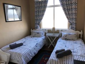 two twin beds in a room with a window at Toms Cabin in Herolds Bay