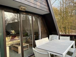 a screened in porch with a table and chairs at Chalet Séquoia 140, Durbuy nature, piscine,2 chiens Ok in Durbuy