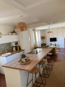 a kitchen with a large wooden table and stools at -La Casa d'Avignon- in Avignon