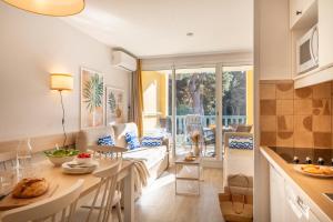 a kitchen and living room with a table and a couch at Résidence Pierre & Vacances La Pinède in Hyères