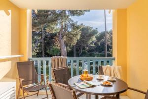 a table and chairs on a balcony with a window at Résidence Pierre & Vacances La Pinède in Hyères
