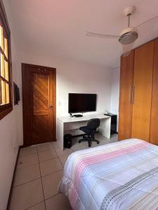 a bedroom with a bed and a desk with a computer at Alugo quarto com internet in Porto Alegre