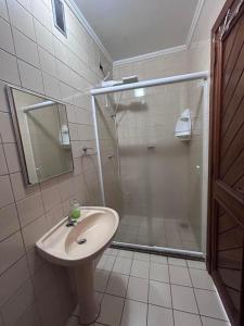 a bathroom with a shower and a sink and a mirror at Alugo quarto com internet in Porto Alegre