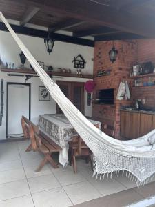 a hammock in a room with a table and a kitchen at Alugo quarto com internet in Porto Alegre