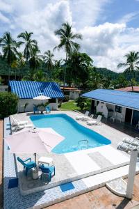 a pool with chairs and umbrellas next to a house at Cabañas Blue in Isla Grande