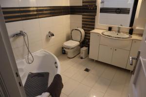 a bathroom with a tub and a toilet and a sink at Galini Home 2 in Prokópion +12 photos