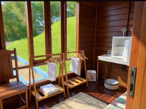 a room with a bathroom with a window and a sink at Chalé Manancial in Socorro
