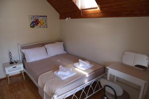 a small bedroom with a bed with two towels on it at Galini Home 2 in Prokópion