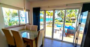 a dining room with a table and a view of the ocean at Panoramic Views Two Decks 1st Row Ocean Kite Beach in Cabarete