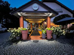 a hotel with potted plants in front of a building at Hotel Nowy Dwór in Trzebnica