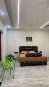 a bedroom with a bed and a green chair at Happy Homes in Jammu