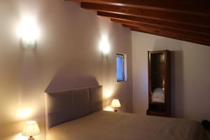 a bedroom with a bed and two lights on the wall at Montes da Barca in Aldeia Nova do Concelho