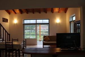 a living room with a table and a large window at Montes da Barca in Aldeia Nova do Concelho