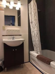a bathroom with a sink and a mirror and a tub at Marland Motel in Powell River
