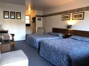 a hotel room with two beds and a chair at Marland Motel in Powell River