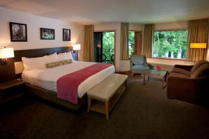 クイノールトにあるLake Quinault Lodgeのベッドと椅子付きのホテルルーム