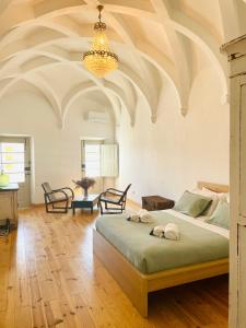 a bedroom with a large bed and a chandelier at Cosmogama House in Évora