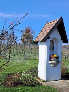 a small dog house with a statue in a vineyard at Gästehaus Linde, Hotel garni in Konstanz